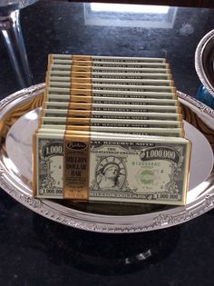 stacks of money sitting on top of a silver plate