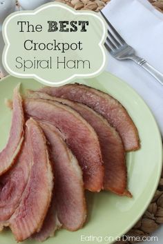 the best crockpot spiral ham on a green plate with silverware and napkins