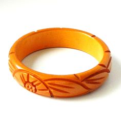 "Item: This is a lovely bakelite bangle bracelet carved with flowers and leaves on either side. It was made in the late 1930s and has a very deep yellow / orange color. It's in excellent condition, has been tested and guaranteed vintage bakelite. Be sure to check our other listings for lots more bakelite jewelry! Measurements: 3/4\" wide - 2 1/2\" inner diameter, 3\" outer diameter, 7 3/4\" inner circumference. Condition: 9.5 - Excellent Shipping: U.S shipping is $5.00 for USPS First Class Mail Vintage Bakelite Bangle Jewelry, Vintage Bakelite Bangle, Vintage Carved Orange Jewelry, Orange Carved Vintage Jewelry, Vintage Orange Carved Jewelry, Vintage Orange Bangle Bracelets, Vintage Bakelite Bracelet, Jewelry Measurements, Bakelite Jewelry