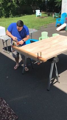 a man working on a wooden table outside