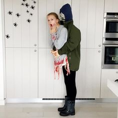 a woman standing in front of a kitchen counter with her mouth open and blood running down the wall