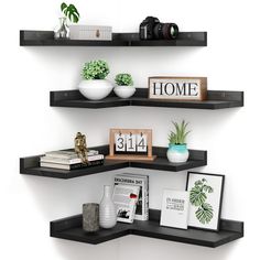 three black shelves with books, plants and pictures on them