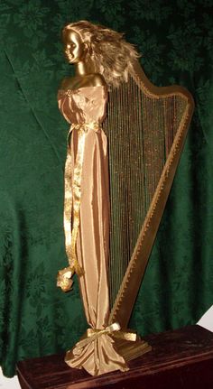 a golden harp sitting on top of a wooden stand in front of a green curtain