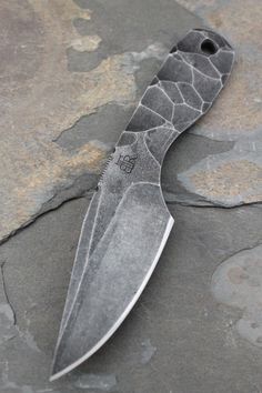 a large knife laying on top of a rock