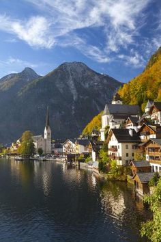 a town on the shore of a lake with mountains in the background