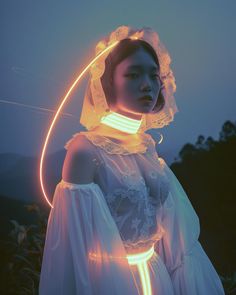 a woman wearing a white dress and headdress with glowing lights in her hair