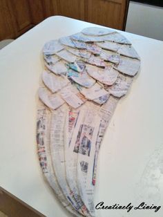 an angel wings made out of newspapers sitting on top of a counter