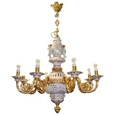 an ornate chandelier with five lights hanging from it's center, in gold and white