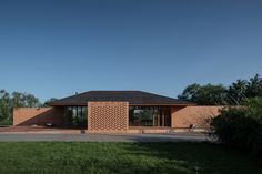 a brick house sitting on top of a lush green field