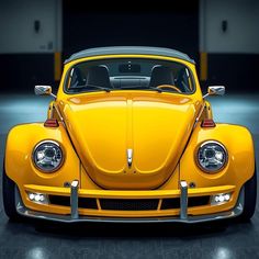 the front end of a yellow vw bug parked in a garage with its lights on