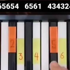 a person is playing the piano with numbers on it and an orange marker in front of them