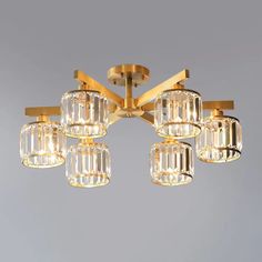 a chandelier with six lights hanging from it's center, and five clear glass cubes on the bottom