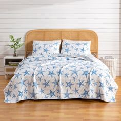 a bed with blue and white starfish print on the sheets, pillows and pillowcases