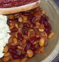 two hot dogs on buns with beans and mashed potatoes are sitting on a plate