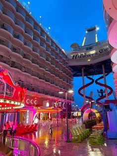 the inside of a cruise ship at night with lights on and water slides in the background