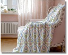 a chair with a blanket on top of it next to a radiator and window