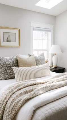 a bed with white sheets and pillows in a bedroom