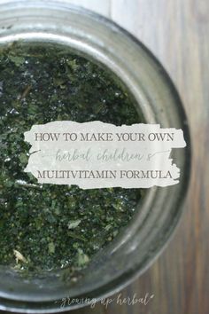 a jar filled with green stuff on top of a wooden table