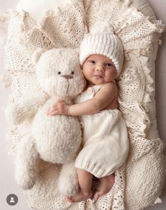 a baby is laying down with a teddy bear