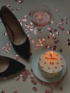 a birthday cake sitting on top of a white plate next to a pair of black shoes