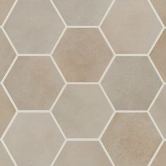 a tile floor with hexagonal shapes in beige and white