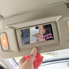 a person is taking a photo in the rear view mirror