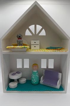 a doll house with furniture and accessories in the front, on a white table top