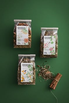 three bags of granola on a green surface with cinnamon sticks and anisette