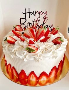 a birthday cake with white frosting and strawberries