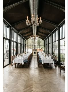 a large dining room with many tables and chairs set up for a formal function in front of huge windows