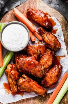 chicken wings with carrots, celery and ranch dressing on a cutting board