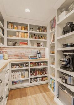 a kitchen with white cabinets and shelves filled with food