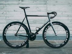 a black and white bike parked in front of a wall