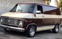 a brown and white van parked in front of a building