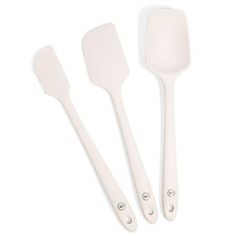 three white spatulas and two spoons on a white background