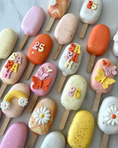 there are many decorated rocks on the sticks and one is pink, orange, yellow