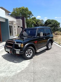 a black suv parked in front of a house