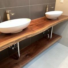 two white bowls are sitting on a wooden shelf