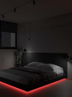 a bed with red lights on it in a dark room next to a wall mounted tv