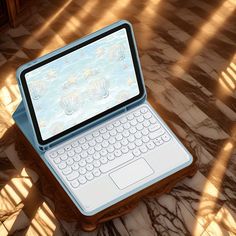 an open laptop computer sitting on top of a wooden table next to a tiled floor