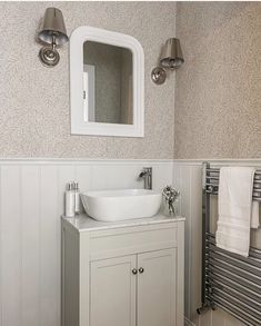 a white sink sitting under a bathroom mirror next to a wall mounted radiator