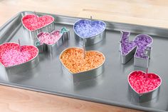 a metal tray topped with lots of heart shaped candies