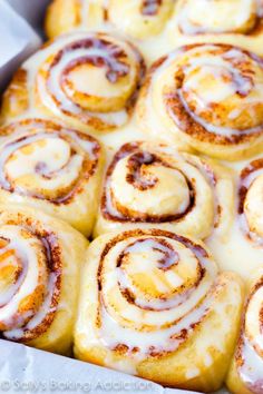 a pan filled with cinnamon rolls covered in icing