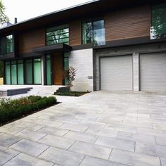 a modern house with two garages and landscaping