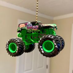 a green monster truck hanging from a ceiling