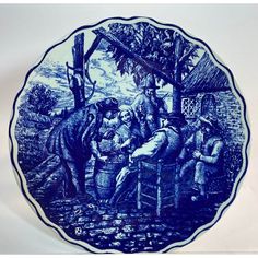 a blue and white plate with an image of people on it