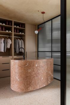 a marble counter in the middle of a walk - in closet