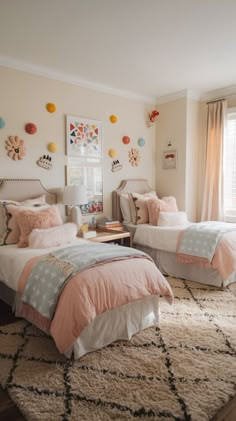 two twin beds in a bedroom with pink and gray bedding