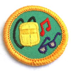 an embroidered badge with sunglasses and music notes on it's side, in yellow thread