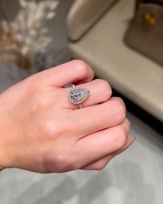 a woman's hand holding a diamond ring